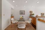 Enjoy intimate meals in this charming dining area, featuring a sleek glass-top table with four elegant chairs.