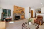 Cozy living room featuring a natural stone fireplace with a rustic wooden mantel, perfect for gathering on cool evenings.