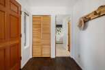Welcome guests into this charming entryway featuring a warm wooden door and convenient louvered closet doors.