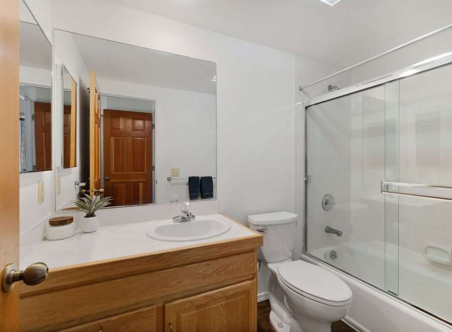 This bathroom features a spacious vanity with ample counter space and a large mirror, perfect for your morning routine.