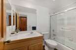 This bathroom features a spacious vanity with ample counter space and a large mirror, perfect for your morning routine.