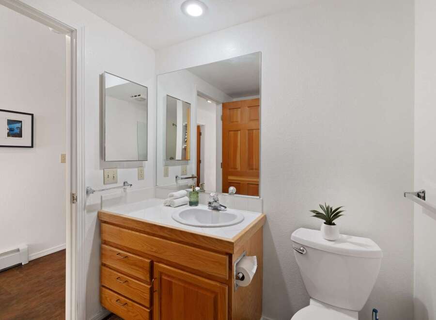 This bathroom features a spacious vanity with ample storage and a large mirror, perfect for your morning routine.