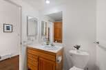 This bathroom features a spacious vanity with ample storage and a large mirror, perfect for your morning routine.