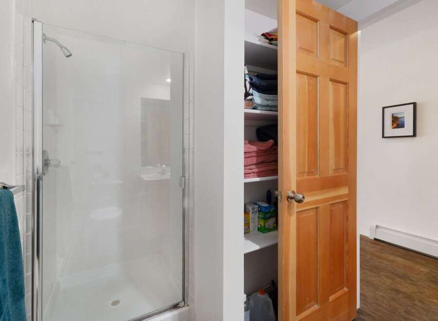 This bathroom features a sleek glass-enclosed shower with white tiled walls, perfect for a refreshing start to your day.