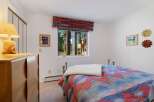 This charming bedroom features a cozy bed adorned with a vibrant, patterned comforter and a plush throw.