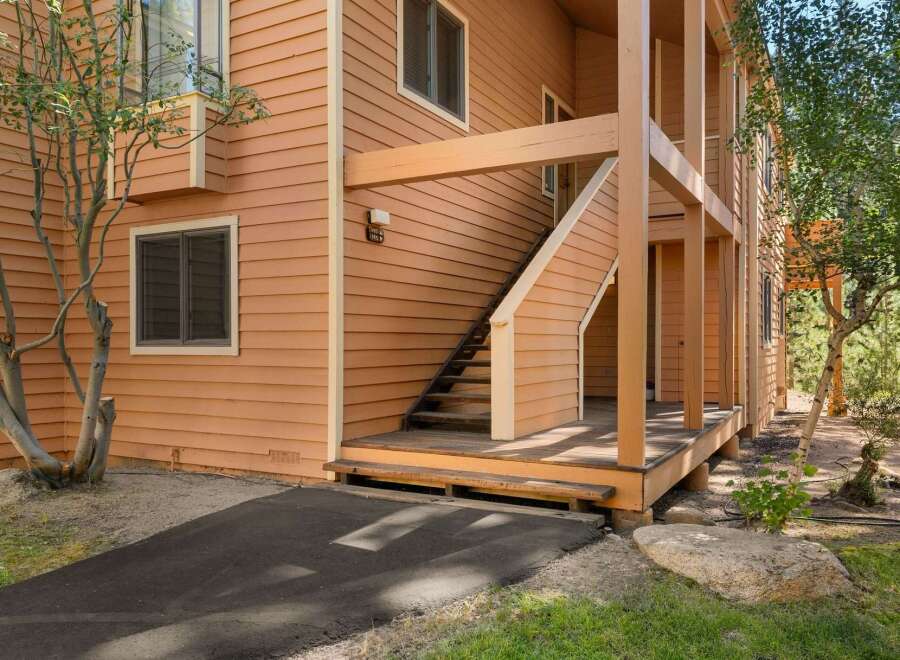 Discover this charming property featuring a warm, inviting exterior with beautiful wood siding and a welcoming staircase leading to the entrance.