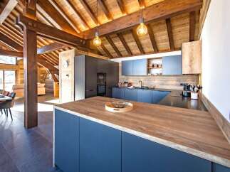 Experience luxury mountain living in this stunning chalet kitchen, featuring a spacious island with a warm wood countertop perfect for entertaining.