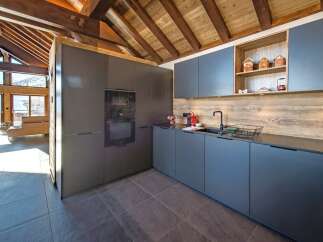 Experience modern luxury in this stunning kitchen featuring sleek, dark cabinetry and integrated appliances.
