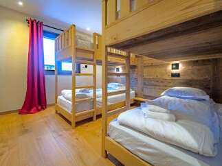 This cozy bedroom features multiple wooden bunk beds, perfect for accommodating families or groups.