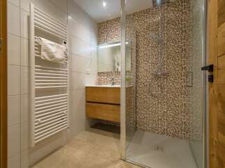 Experience modern comfort in this beautifully appointed bathroom, featuring a sleek glass-enclosed shower with stylish patterned tiles.