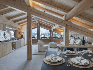 Experience luxurious alpine living in this stunning chalet featuring a vaulted wooden beam ceiling and panoramic mountain views.