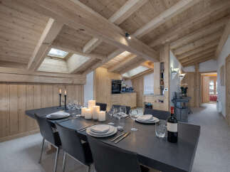 Experience rustic charm in this mountain chalet dining area, featuring a large wooden table set for a feast.