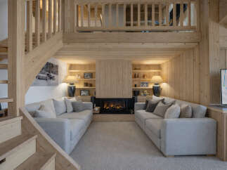 Experience ultimate relaxation in this cozy living room, featuring two plush sofas facing a modern fireplace.