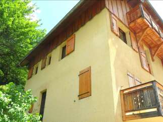 Charming alpine property featuring a warm, textured yellow stucco exterior complemented by rich wooden accents.