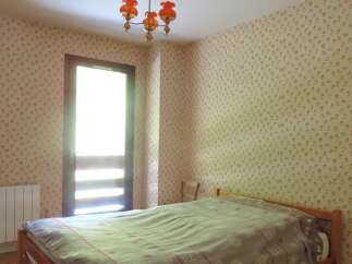 This charming bedroom features a cozy bed dressed in a patterned duvet, perfect for relaxation.