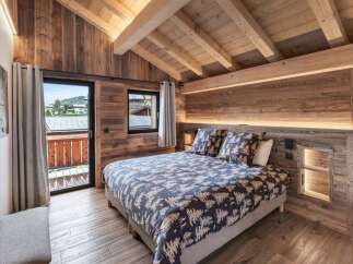 Experience rustic charm in this cozy mountain bedroom, featuring a comfortable bed adorned with nature-inspired linens.