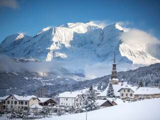 Experience the charm of a winter wonderland with this picturesque village nestled at the foot of majestic snow-capped mountains.