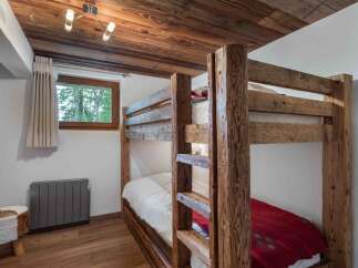 Experience rustic charm in this cozy bedroom featuring a sturdy wooden bunk bed, perfect for families or guests.