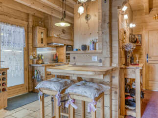 Experience rustic charm in this cozy wooden kitchen, featuring a breakfast bar with comfortable seating and ample storage.