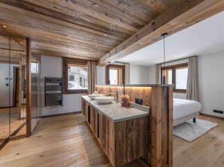 Experience rustic luxury in this stunning bathroom featuring a double vanity with vessel sinks and a granite countertop, complemented by warm wood cabinetry and a wooden plank ceiling.