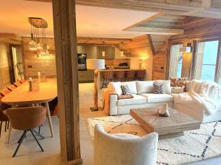Experience luxurious mountain living in this stunning open-concept living space, featuring a modern kitchen with a breakfast bar and a cozy dining area perfect for gatherings.