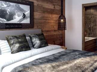 Experience rustic luxury in this charming bedroom featuring a cozy bed adorned with plush throws and decorative pillows.