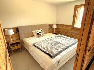 Experience cozy mountain living in this charming bedroom, featuring a comfortable bed adorned with a decorative pillow and a plush throw blanket.
