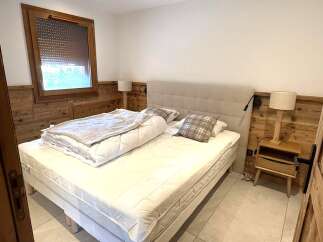 Experience cozy mountain living in this charming bedroom featuring a comfortable bed with plush bedding and decorative pillows.
