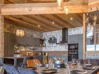Experience luxurious mountain living in this stunning chalet featuring a modern kitchen and dining area perfect for entertaining.