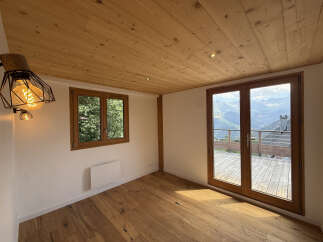Experience breathtaking mountain views from this stunning room featuring a natural wood ceiling and flooring.