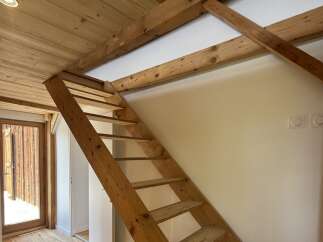 Discover this charming property featuring a rustic wooden staircase leading to an upper level.