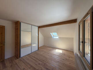 Discover this charming attic bedroom featuring a spacious built-in wardrobe with mirrored doors, perfect for maximizing light and space.