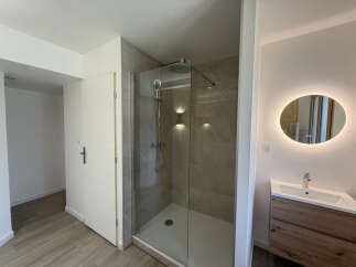 Experience modern luxury in this beautifully appointed bathroom, featuring a spacious walk-in shower with elegant marble-look tiles and a rainfall showerhead.