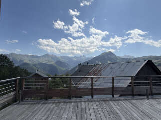 Experience breathtaking mountain views from this stunning property, featuring a spacious wooden deck perfect for outdoor living.