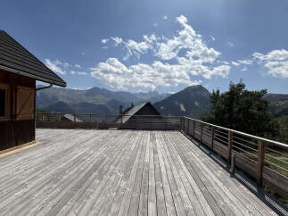 Experience breathtaking mountain views from this expansive wooden deck, perfect for outdoor entertaining or quiet relaxation.