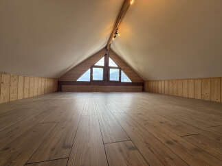 Discover this charming attic space, featuring a beautiful wooden floor and paneled walls, perfect for a cozy retreat or extra living area.