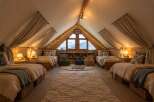 Experience the ultimate cozy retreat in this charming attic bedroom, perfect for family adventures.