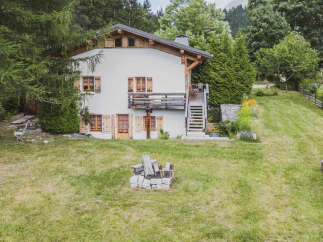 Nestled amidst lush greenery, this charming chalet offers a serene mountain retreat.