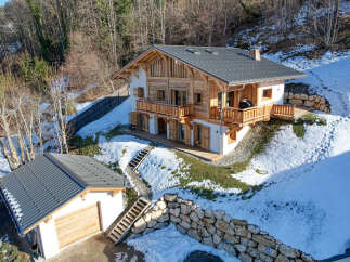 Experience the charm of this stunning wooden chalet nestled in a snowy mountain landscape.