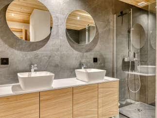 Experience modern luxury in this stunning bathroom featuring a double vanity with sleek square sinks and contemporary chrome faucets.