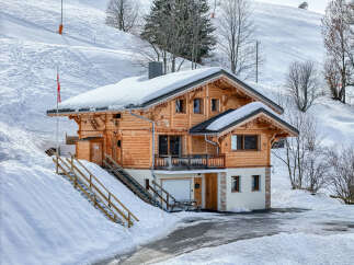 Experience the ultimate alpine getaway in this charming wooden chalet, nestled on a snowy mountainside.