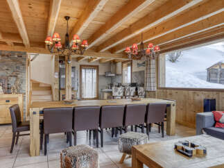 Experience rustic charm in this spacious dining area, featuring a large wooden table with comfortable leather chairs, perfect for family gatherings.
