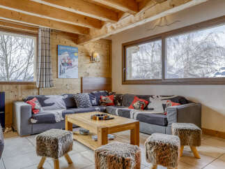 Experience cozy mountain living in this charming living room featuring a sectional sofa adorned with decorative pillows and a rustic wooden coffee table.