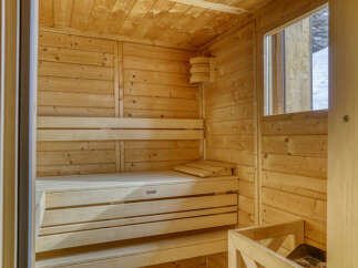Experience ultimate relaxation in this beautifully crafted wooden sauna, featuring multi-level benches for personalized comfort.