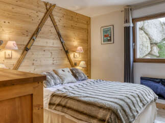 Experience rustic charm in this cozy bedroom, featuring a unique wooden headboard adorned with vintage skis.