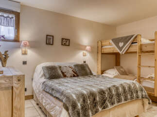 This charming bedroom features a cozy double bed adorned with a plush faux fur throw and decorative pillows, perfect for a relaxing retreat.