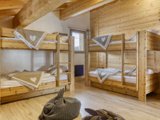 Experience cozy mountain living in this charming wooden cabin, featuring two sets of sturdy wooden bunk beds perfect for families or groups.
