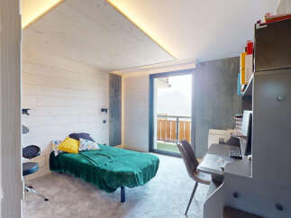 Discover this charming room featuring a comfortable single bed with a vibrant green throw, perfect for relaxation.