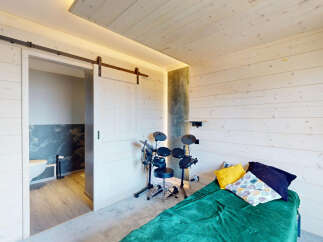 Experience modern living in this stylish room featuring a unique sliding barn door that opens to a private bathroom.