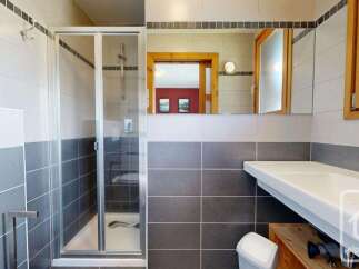 This modern bathroom features a sleek shower enclosure with glass doors and a chrome showerhead.